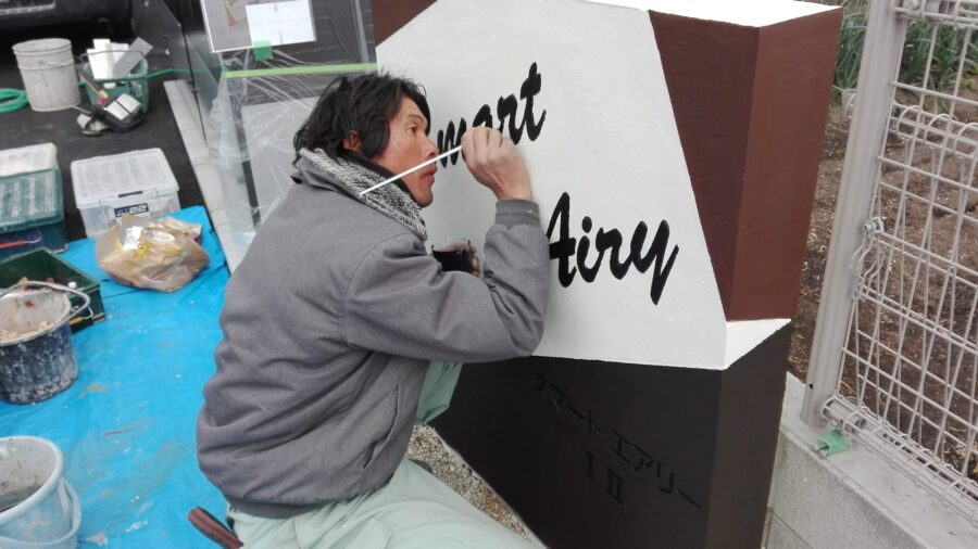 擬石門柱へのロゴ描き作業