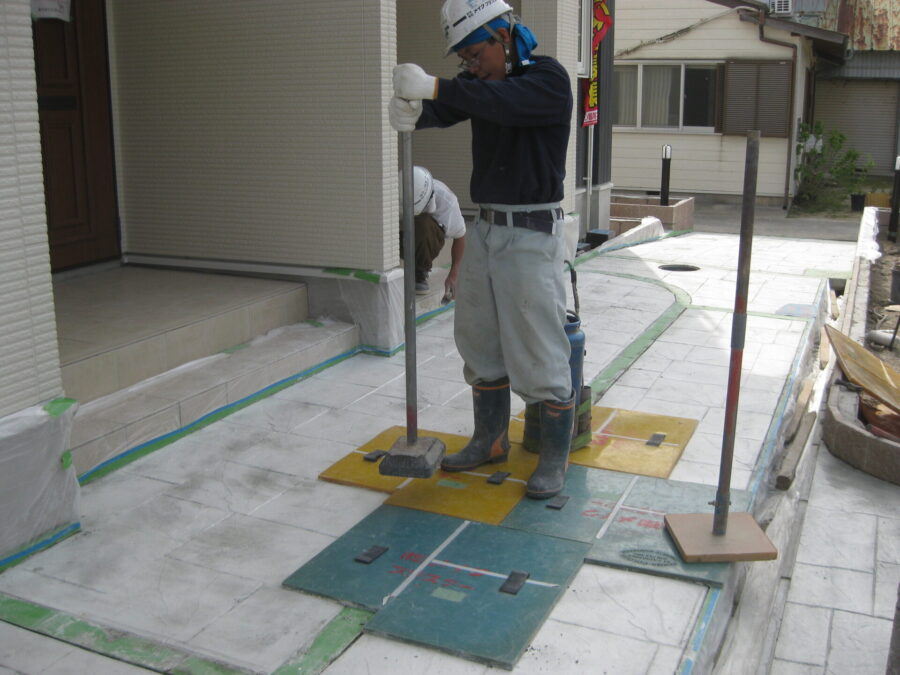 スタンプマットで模様を形成し、目地と凹凸を再現する職人の作業。