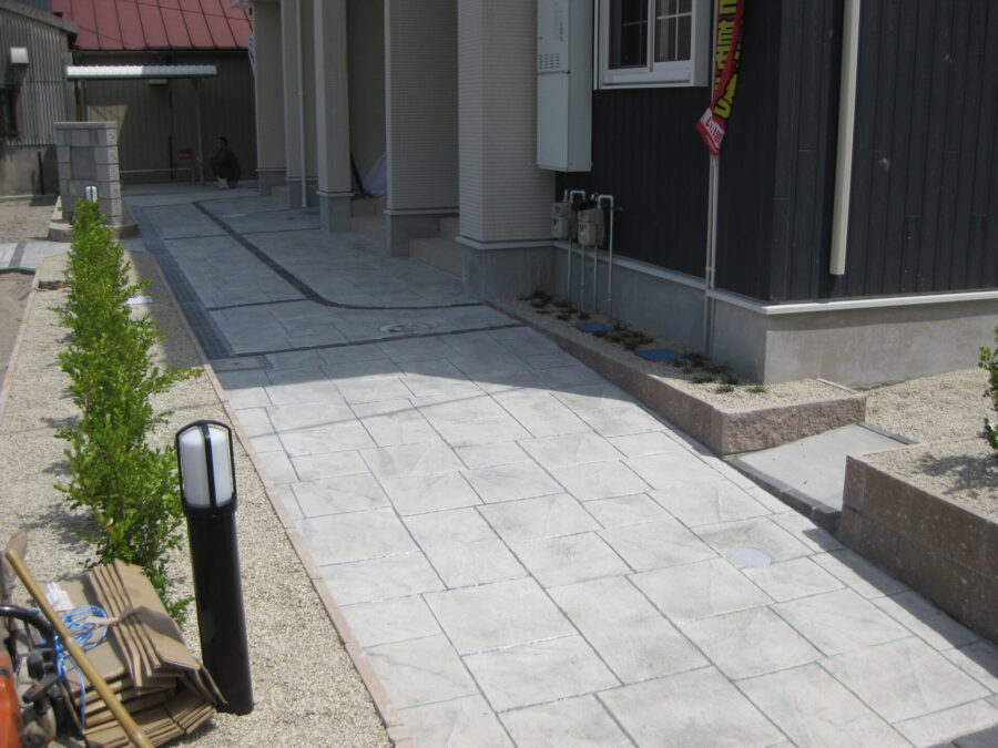 スタンプコンクリートが完成し、発色と質感が整った玄関アプローチ全景。