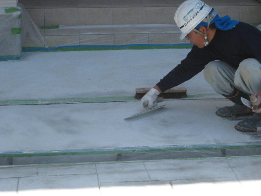 カラーハードナーを金鏝で刷り込み、表面に定着させる工程（アパートのアプローチ）